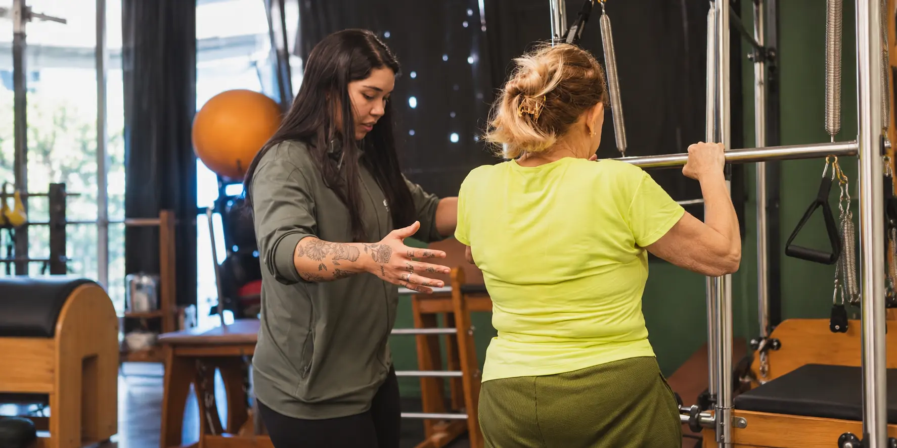 Aluna realizando um exercício com acompanhamento próximo de uma profissional da Everylife